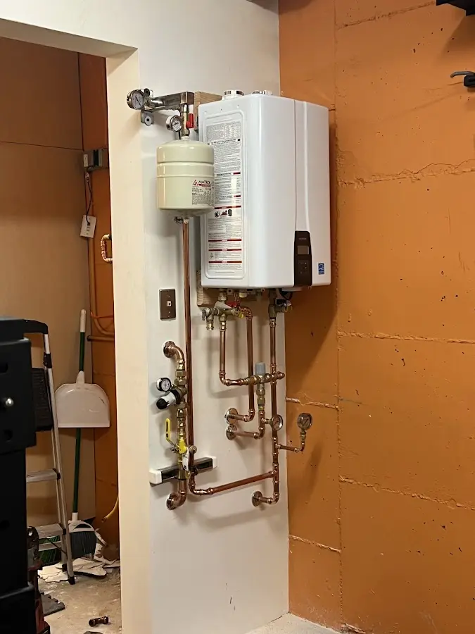 Plumbing technician inspecting water heater connections in Great Falls